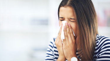 a woman showing common allergy symptoms triggered by air pollution in urban areas